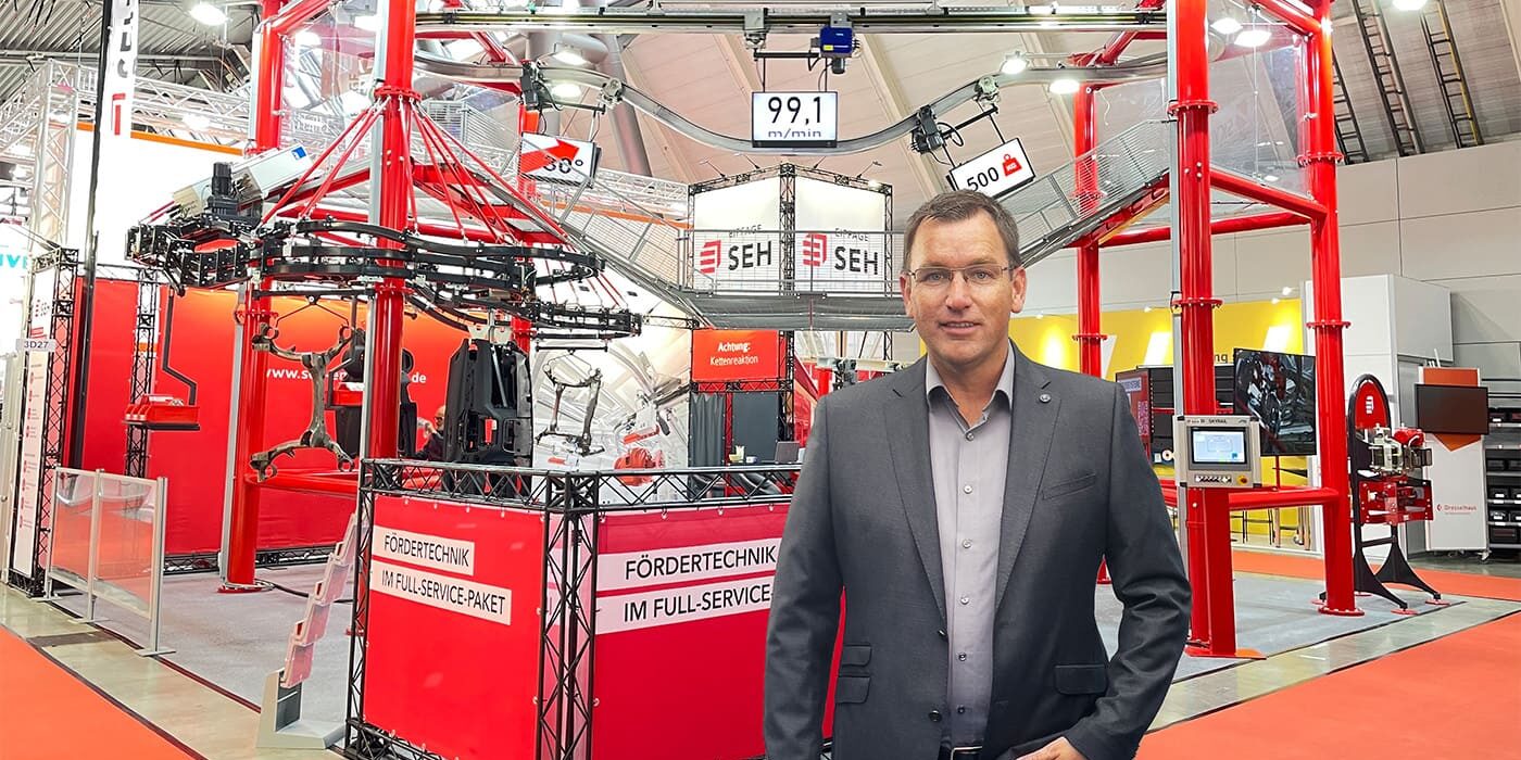 Carsten Schmidt steht vor dem Messestand von SEH Engineering