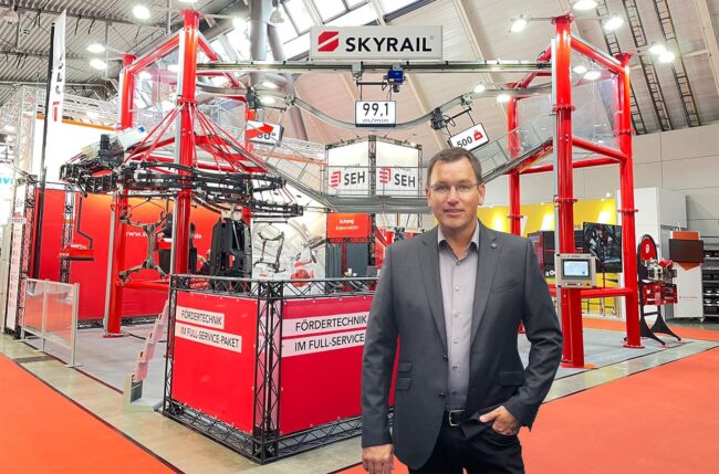 Carsten Schmidt steht vor dem Messestand von SEH Engineering