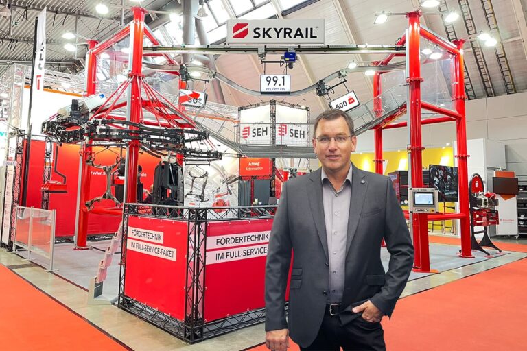 Carsten Schmidt steht vor dem Messestand von SEH Engineering